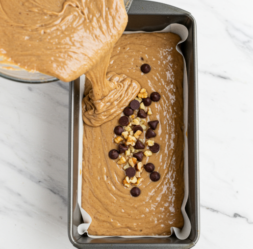 batter being poured into the loaf pan